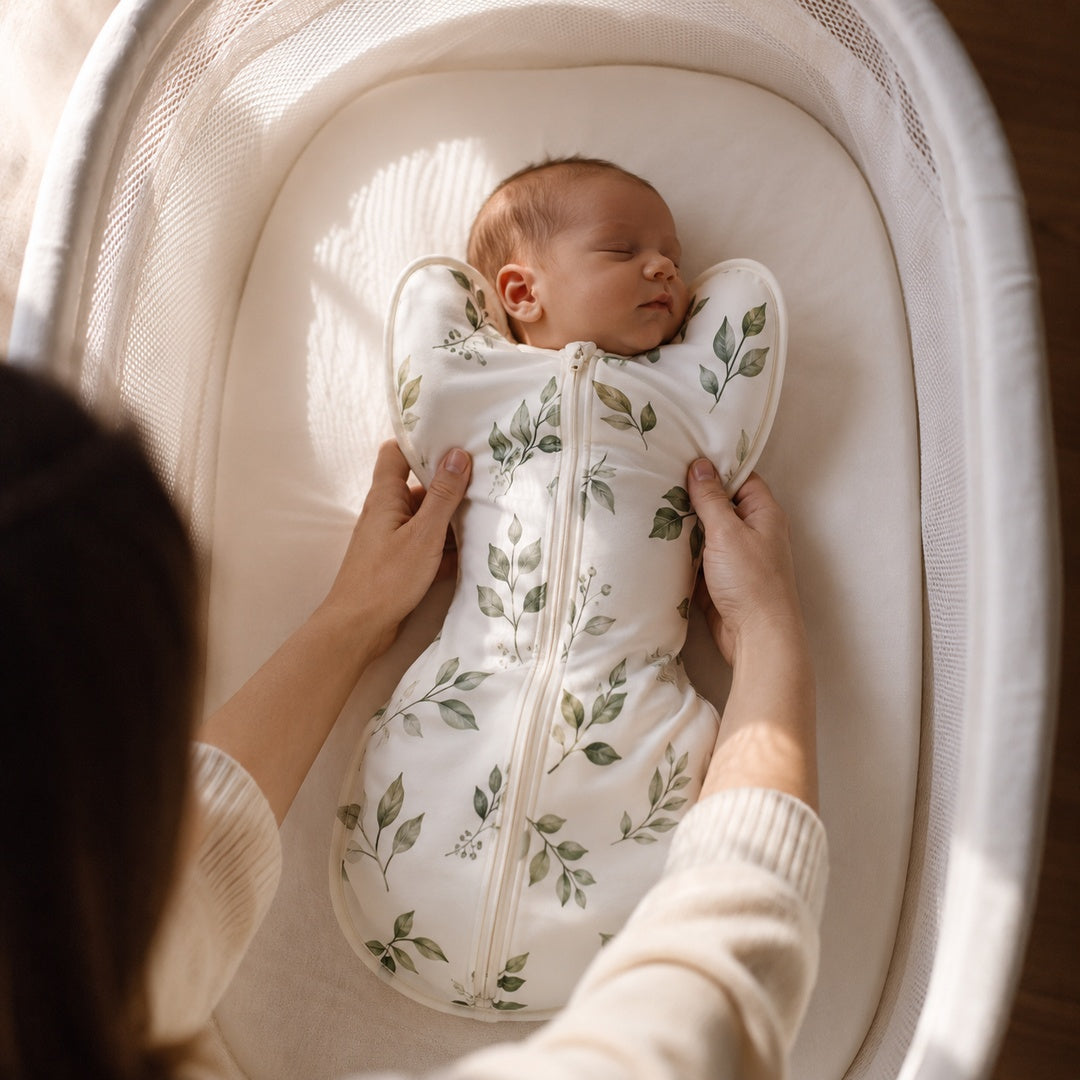 Parent lowering baby in the CradleUp swaddle into a bassinet